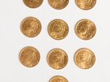 several gold coins are arranged in a triangle on a white surface
