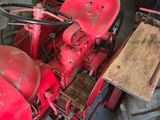 a red tractor that is parked in a garage