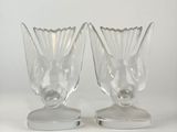 two clear glass vases sitting on top of a metal stand