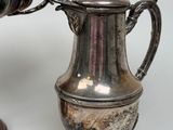 two silver vases sitting next to each other on a table