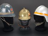 three helmets that are on display on a black table