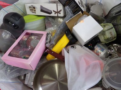 pile of assorted kitchen items in a plastic container on a table