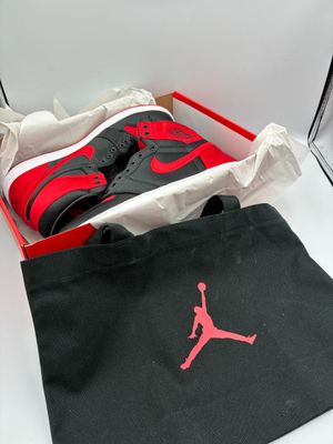 nike air jordans in a box with a black bag and a red shoe