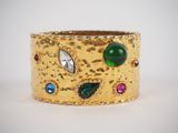 a close up of a gold ring with multi colored stones