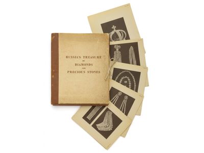 un vieux livre posé sur une table, à côté d'une pile de photos