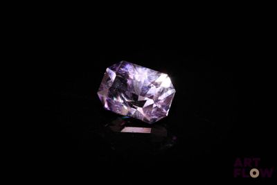 a close up of a purple diamond on a black surface