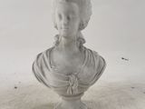 white marble bust of a woman with braids on her hair