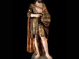 statue of a man with a beard and a robe holding a book