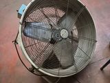 a fan that is sitting on the floor next to a chair