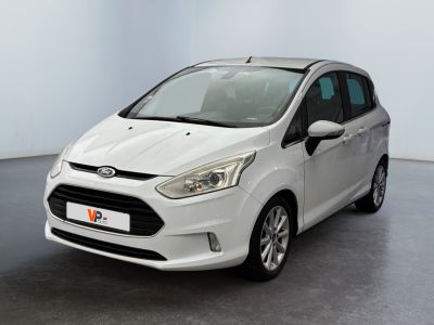 a white car is parked in a room with a black floor