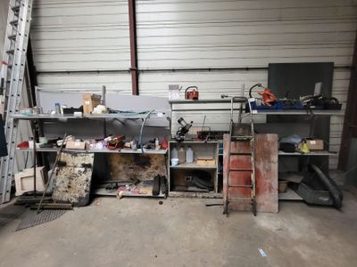 une pièce équipée d'une échelle, d'étagères et d'un établi