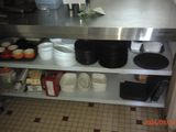 many plates and bowls on the shelf in the kitchen