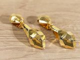 pair of gold plated earrings on a wooden surface