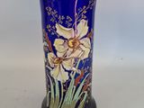 a blue vase with flowers on it sitting on a table