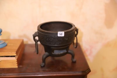 un pot noir posé sur une table, à côté d'une bougie bleue