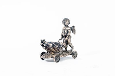 une figurine en argent représentant un garçon à moto