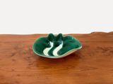 un bol vert et blanc posé sur une table en bois