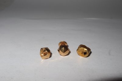 two gold studs sitting on top of a white surface