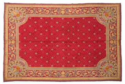 a red rug with a gold border and a floral design