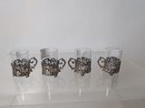 four shot glasses sitting on top of a clear table next to each other