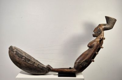 une sculpture en bois représentant un homme jouant d'un instrument de musique