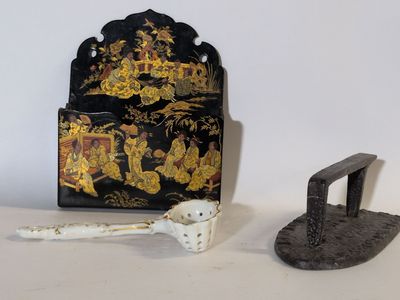 une boîte noire et dorée et une paire de pinces en fer