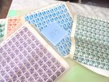 de nombreux timbres posés sur une table sur laquelle se trouve une feuille de papier