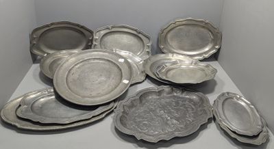de nombreuses assiettes en argent posées sur une table blanche