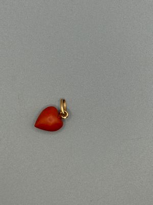 an image of a red heart charm on a gray surface