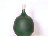 un grand vase vert posé sur une boîte blanche