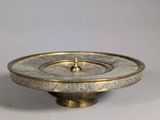 an image of a brass plate with a decorative design on it