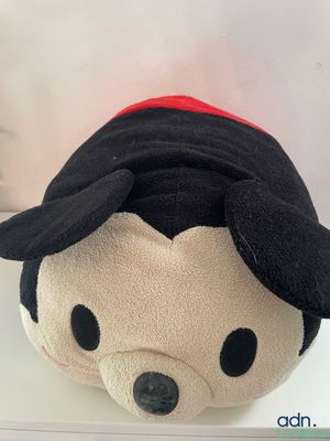 mickey mouse plush toy sitting on top of a white shelf