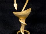 une sculpture en or représentant un cygne, posée sur un socle noir