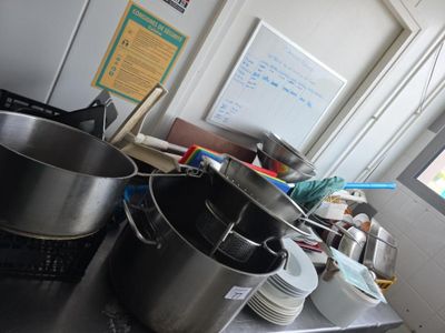 des casseroles et des poêles posées sur une table dans une cuisine dotée d'une fenêtre