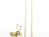 un collier de perles blanches orné d'un pendentif en forme d'oiseau en or et une paire de boucles d'oreilles
