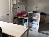 a room with a table, chairs, and a refrigerator in it