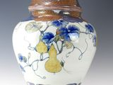 un vase bleu et blanc orné de poires et de fleurs