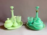 two green vases and a tea set on a table