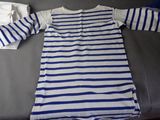 a blue and white striped shirt on a bed next to a pillow