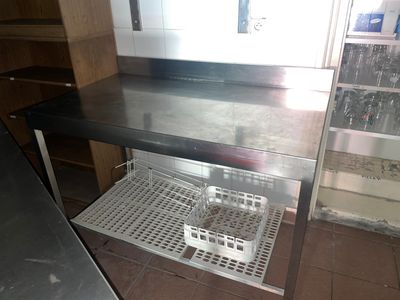 une étagère en métal sur laquelle est posé un panier, dans une cuisine