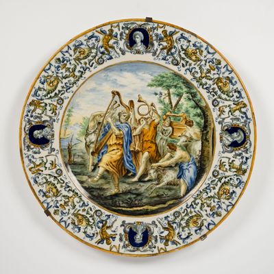 une assiette décorée d'une peinture, accrochée au mur