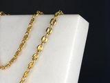 a close up of a gold chain on a white marble block