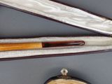 two pens in a case on a table next to a purse