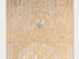 a gold and white embroidered wall hanging with an image of a woman in a blue dress