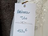 a label on a wedding dress hanging on a mannequin