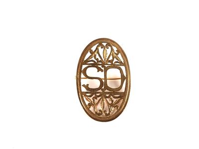 une photo d'une broche en or sur fond blanc