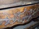 a close up of a wooden bench with a carved design on it