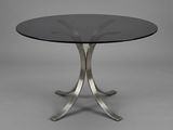 une table ronde en verre avec des pieds en métal et un plateau en verre