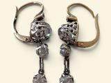 une paire de boucles d'oreilles anciennes en argent et diamants sur fond blanc