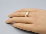 a woman ' s hand with a gold ring on it